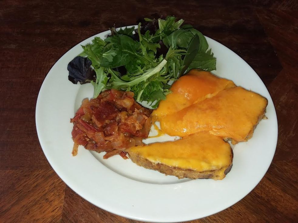 an open-faced cheddar and horseradish sandwich with tomato-bacon jam and a side salad