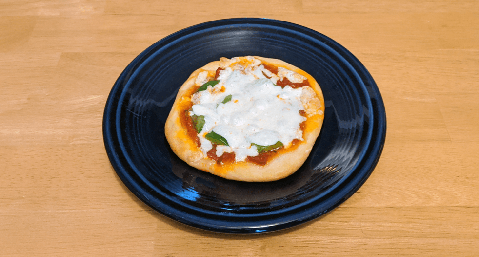 a mini pizza on a dark blue plate